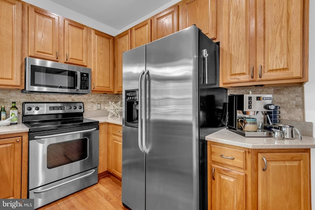 620 Cypress Ln, Severna Park, MD 21146 - kitchen featuring appliances with stainless steel finishes, decorative backsplash, light countertops, and light wood-style flooring