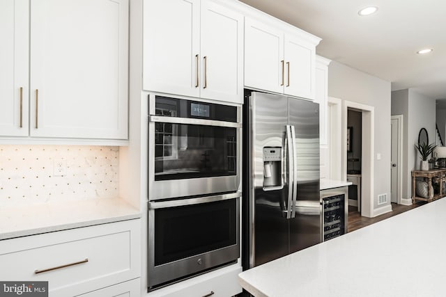 2638 Hollow View Dr, Easton, PA 18040 - kitchen featuring appliances with stainless steel finishes, beverage cooler, light countertops, tasteful backsplash, and recessed lighting