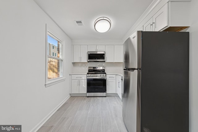 1329 Potomac Heights Dr Unit 36, Fort Washington, MD 20744 - kitchen featuring appliances with stainless steel finishes, backsplash, white cabinetry, light countertops, and baseboards
