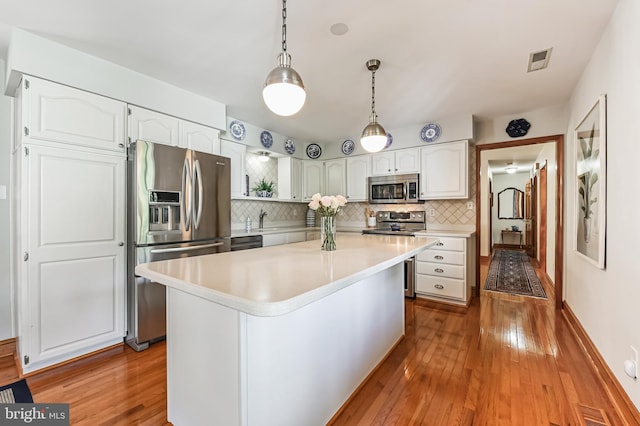 665 Bayard Rd, Lothian, MD 20711 - kitchen with stainless steel appliances, hardwood / wood-style floors, white cabinetry, and light countertops