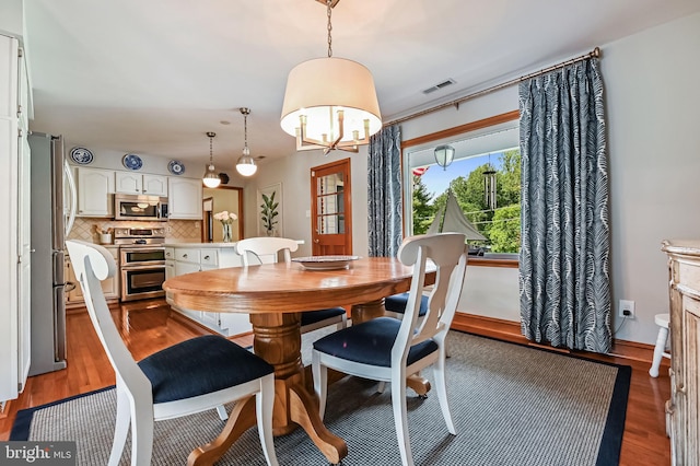 665 Bayard Rd, Lothian, MD 20711 - dining room featuring wood finished floors, a chandelier, and baseboards