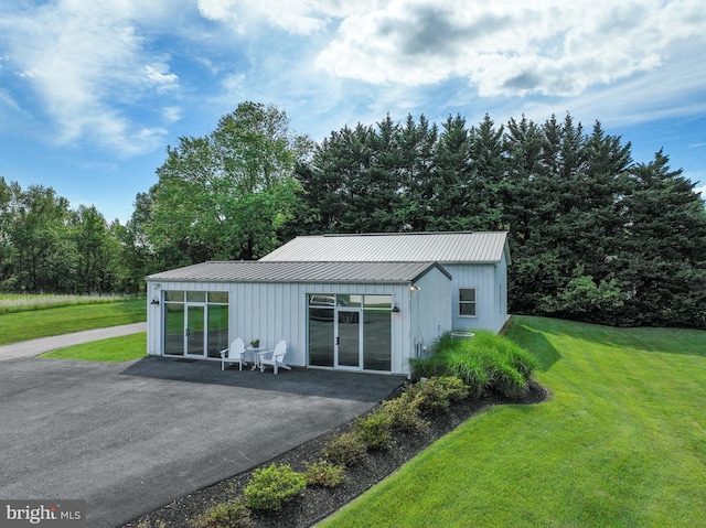 665 Bayard Rd, Lothian, MD 20711 - view of front facade featuring board and batten siding, a front lawn, metal roof, a standing seam roof, and a patio