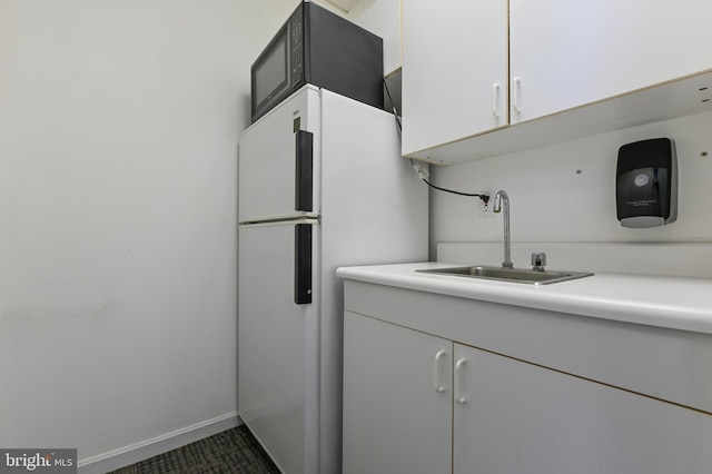 665 Bayard Rd, Lothian, MD 20711 - kitchen featuring freestanding refrigerator, a sink, light countertops, and white cabinets
