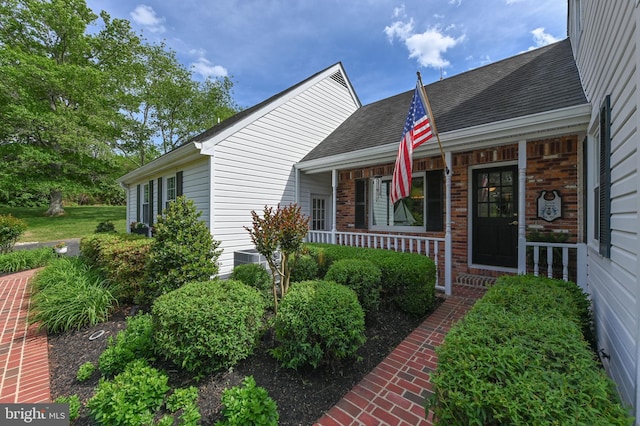 665 Bayard Rd, Lothian, MD 20711 - view of front of house with a porch, a shingled roof, brick siding, and central AC unit