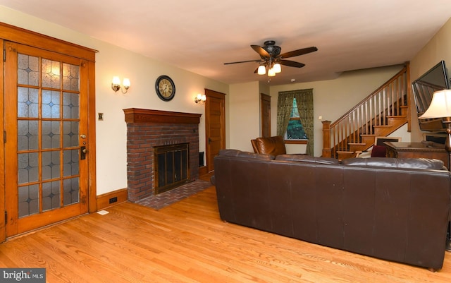 67 N American St, Woodbury, NJ 08096 - living area with wood finished floors, a ceiling fan, a brick fireplace, and stairway