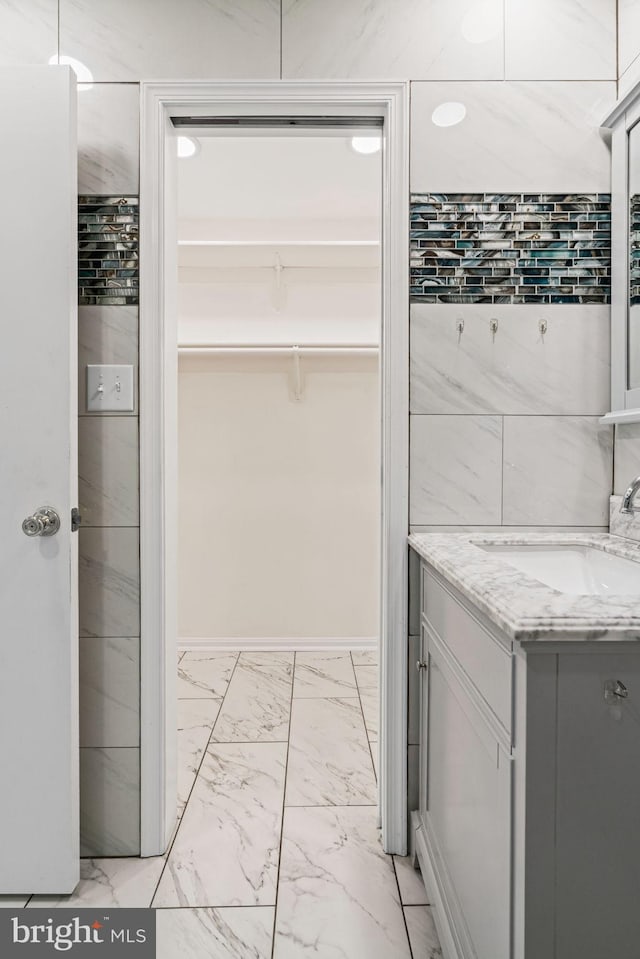 6188 Cobbs Rd, Alexandria, VA 22310 - bathroom with marble look tiles, vanity, and a walk in closet
