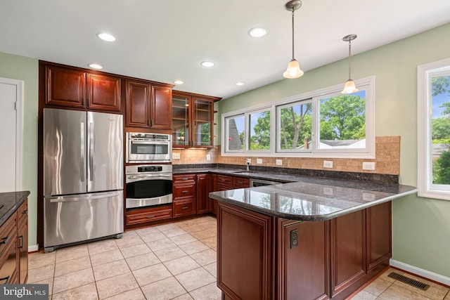 6188 Cobbs Rd, Alexandria, VA 22310 - kitchen with appliances with stainless steel finishes, plenty of natural light, a peninsula, decorative backsplash, and recessed lighting