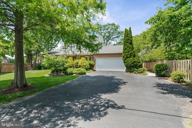 6188 Cobbs Rd, Alexandria, VA 22310 - view of property hidden behind natural elements with asphalt driveway, an attached garage, and brick siding