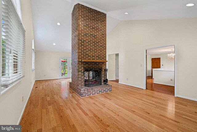 6188 Cobbs Rd, Alexandria, VA 22310 - unfurnished living room with high vaulted ceiling, a brick fireplace, wood finished floors, and a chandelier