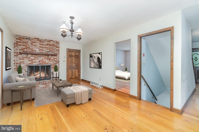 56 Pine Dr, Kirkwood, PA 17536 - living area featuring a chandelier, hardwood / wood-style floors, a brick fireplace, and baseboards