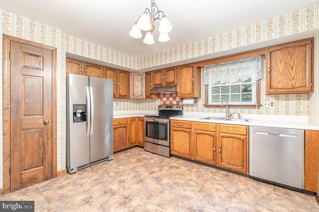 56 Pine Dr, Kirkwood, PA 17536 - kitchen featuring appliances with stainless steel finishes, a sink, wallpapered walls, a chandelier, and brown cabinetry