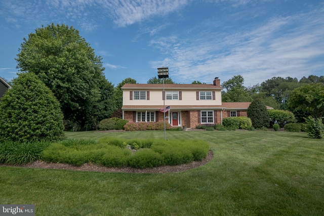 65 White Bark Dr, Middletown, DE 19709 - traditional-style house featuring brick siding, a chimney, and a front lawn