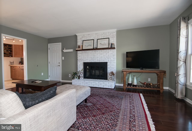 65 White Bark Dr, Middletown, DE 19709 - living area with wood finished floors, a brick fireplace, and baseboards