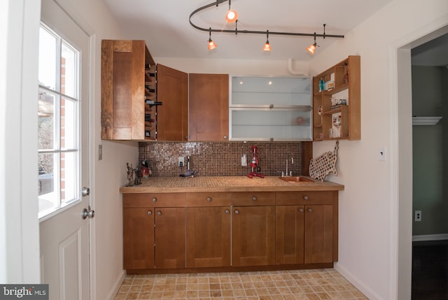 65 White Bark Dr, Middletown, DE 19709 - kitchen with brown cabinetry, a sink, light countertops, tasteful backsplash, and plenty of natural light