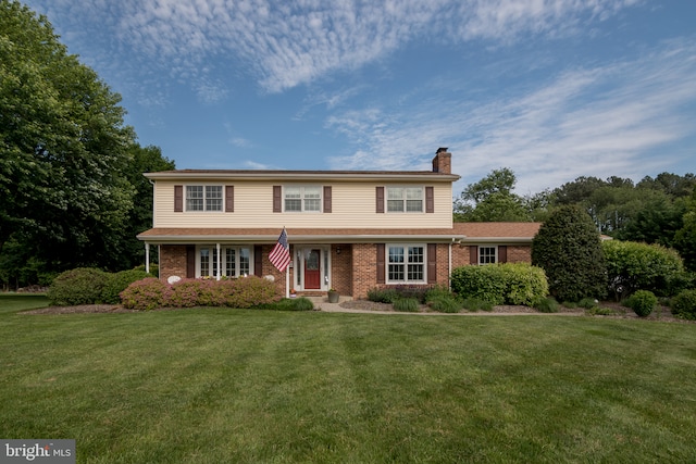 65 White Bark Dr, Middletown, DE 19709 - traditional home featuring a chimney, brick siding, and a front lawn