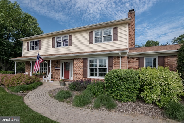 65 White Bark Dr, Middletown, DE 19709 - traditional-style house featuring a chimney, brick siding, and a porch