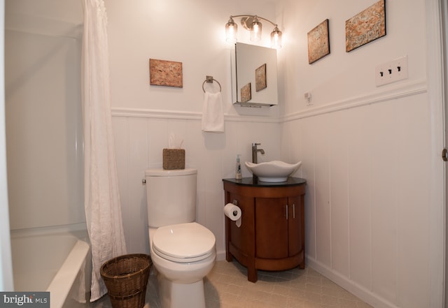 65 White Bark Dr, Middletown, DE 19709 - bathroom featuring a wainscoted wall, vanity, toilet, tile patterned flooring, and shower / bath combo with shower curtain
