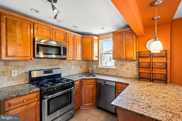 602 Braxton Rd, Ridley Park, PA 19078 - kitchen with stainless steel appliances, a sink, light stone counters, and brown cabinets