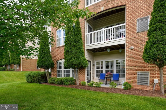8145 Cyprus Cedar Ln Unit C, Ellicott City, MD 21043 - rear view of property with a balcony, a lawn, and brick siding