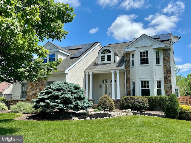 55 W Windrose Dr, Richboro, PA 18954 - view of front of home featuring stone siding, roof mounted solar panels, and a front lawn