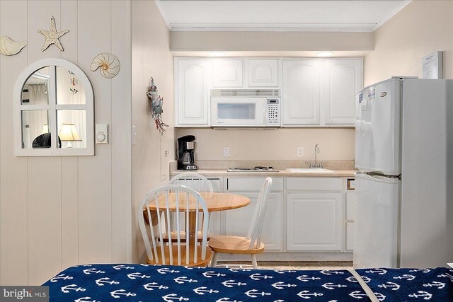 3010 Philadelphia Ave Unit S106, Ocean City, MD 21842 - kitchen with white appliances, crown molding, a sink, white cabinetry, and light countertops