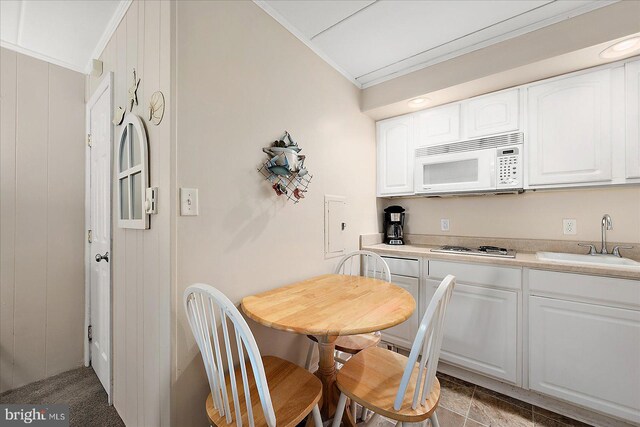 3010 Philadelphia Ave Unit S106, Ocean City, MD 21842 - kitchen with white microwave, a sink, white cabinets, and light countertops