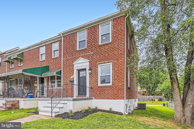 1235 Delbert, Baltimore, MD 21222 - view of property featuring brick siding, central AC unit, and a front yard