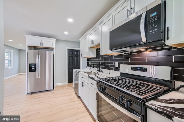 1235 Delbert, Baltimore, MD 21222 - kitchen featuring appliances with stainless steel finishes, a sink, light wood finished floors, decorative backsplash, and baseboards
