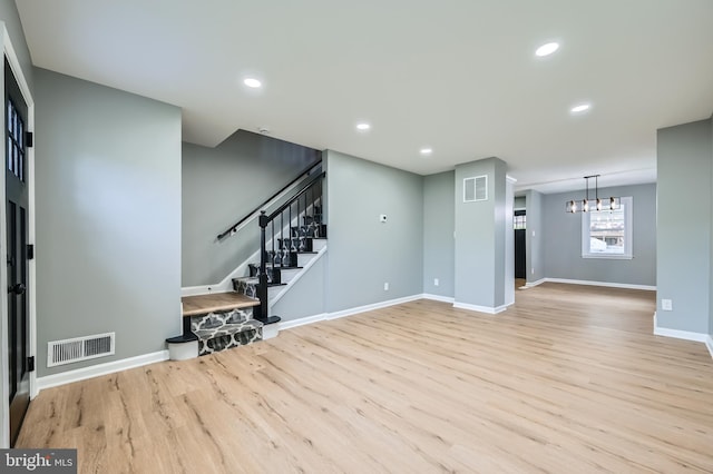 1235 Delbert, Baltimore, MD 21222 - unfurnished living room featuring wood finished floors, a chandelier, stairway, baseboards, and recessed lighting