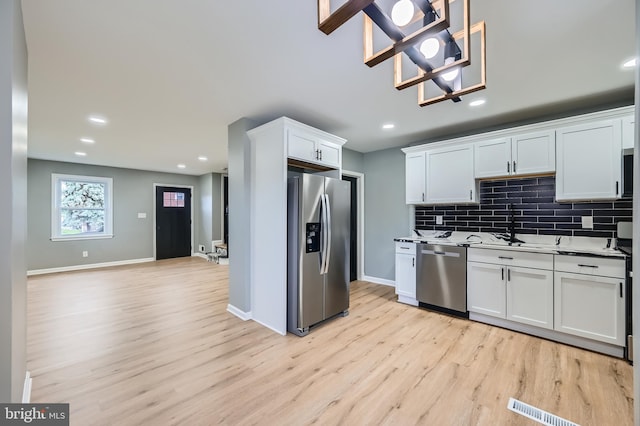 1235 Delbert, Baltimore, MD 21222 - kitchen featuring stainless steel appliances, light wood-style floors, a chandelier, decorative backsplash, and recessed lighting