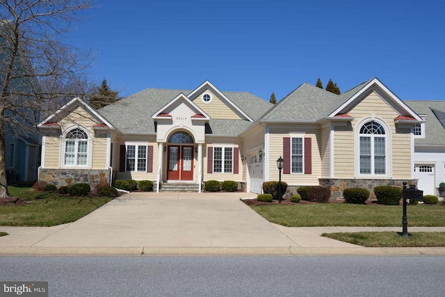 35517 Bonaire Dr, Rehoboth Beach, DE 19971 - view of front facade with stone siding, a front yard, concrete driveway, a shingled roof, and entry steps