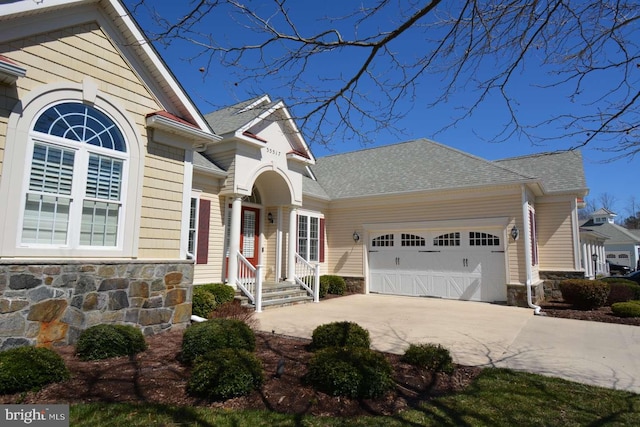 35517 Bonaire Dr, Rehoboth Beach, DE 19971 - view of front of property with stone siding, concrete driveway, an attached garage, and a shingled roof