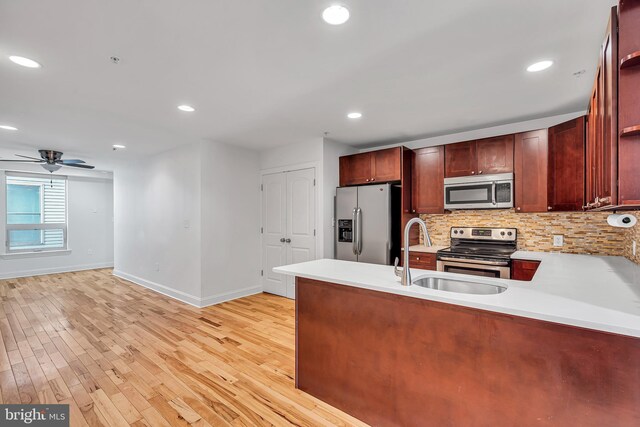 821 N 15th St Unit 2, Philadelphia, PA 19130 - kitchen featuring appliances with stainless steel finishes, baseboards, a sink, a peninsula, and decorative backsplash