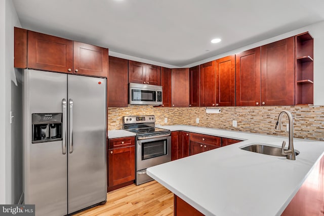 821 N 15th St Unit 2, Philadelphia, PA 19130 - kitchen with stainless steel appliances, a sink, open shelves, reddish brown cabinets, and light wood finished floors