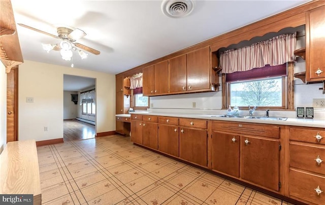 1195 Hemlock St, Palmerton, PA 18071 - kitchen with a sink, light countertops, ceiling fan, brown cabinets, and baseboards
