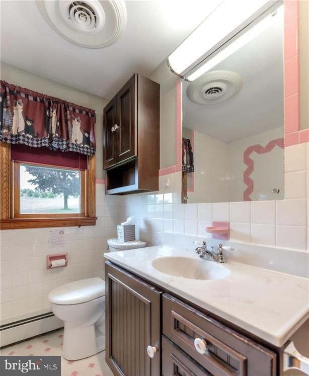 1195 Hemlock St, Palmerton, PA 18071 - bathroom with a baseboard heating unit, tile walls, vanity, and toilet