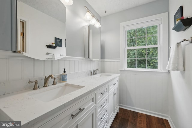 4549 Diehl Ct, Woodbridge, VA 22193 - bathroom featuring double vanity, wood finished floors, wainscoting, and a decorative wall