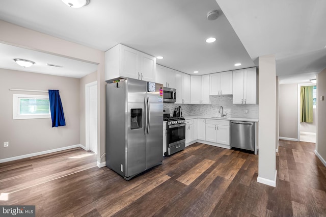 20 Village Rd, Baltimore, MD 21208 - kitchen with stainless steel appliances, light countertops, dark wood-style floors, backsplash, and white cabinets