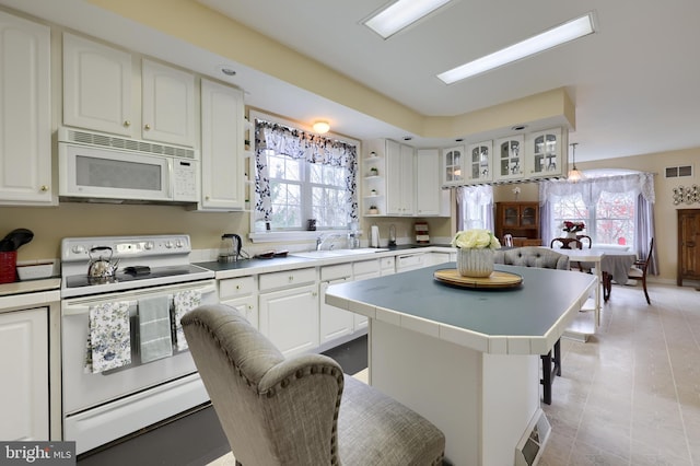 114 Moore Ln, Gap, PA 17527 - kitchen featuring white appliances, a kitchen island, white cabinets, light countertops, and plenty of natural light