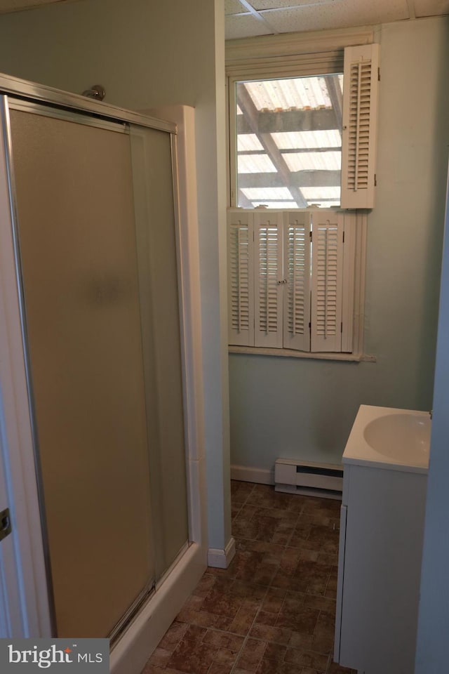 85 S St, Hanover, PA 17331 - full bathroom featuring a baseboard heating unit, a stall shower, vanity, a paneled ceiling, and stone finish floors
