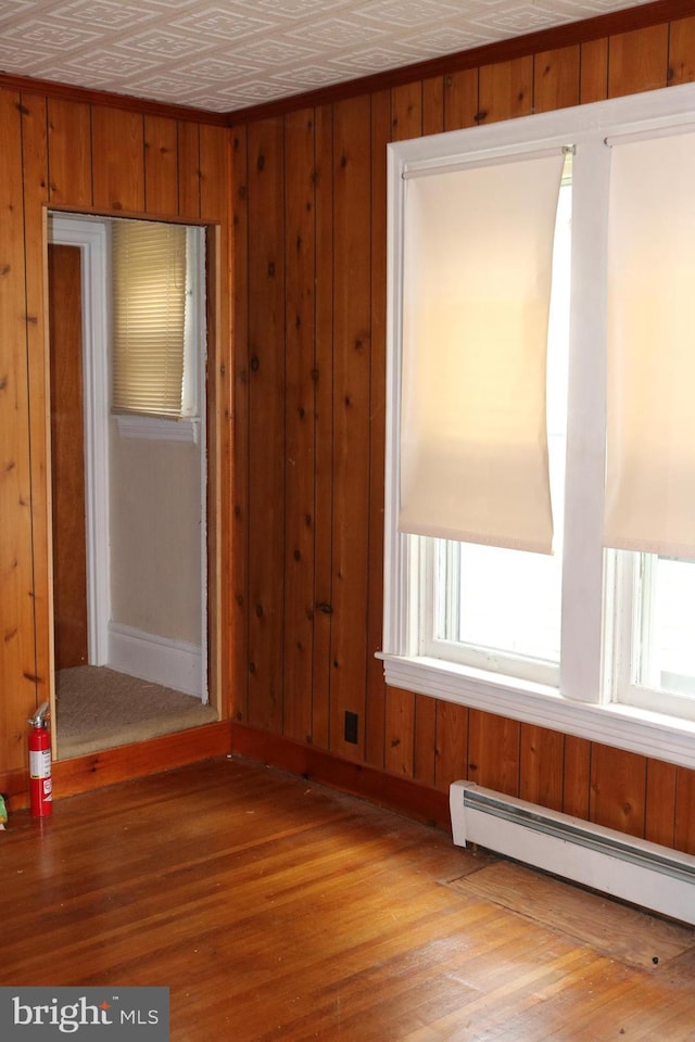 85 S St, Hanover, PA 17331 - empty room featuring a baseboard radiator, wood finished floors, and wooden walls