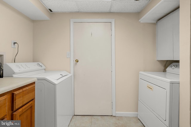 5604 Edgemont Dr, Alexandria, VA 22310 - laundry area with washing machine and dryer, light tile patterned floors, cabinet space, and baseboards