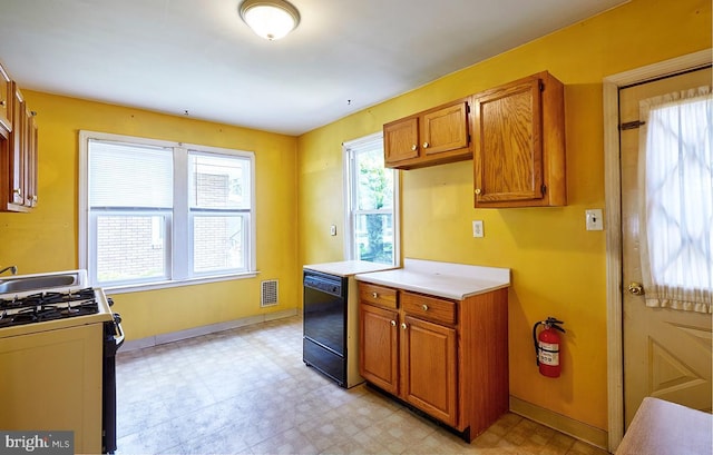 625 Hunter St, Gloucester City, NJ 08030 - kitchen featuring gas range, black dishwasher, light flooring, and brown cabinets