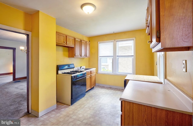 625 Hunter St, Gloucester City, NJ 08030 - kitchen with gas stove, baseboards, a chandelier, and light countertops