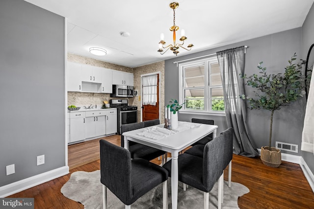 2521 Moore Ave, Baltimore, MD 21234 - dining room featuring baseboards, a chandelier, and dark wood-style flooring