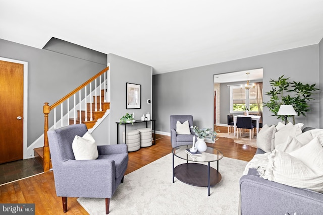 2521 Moore Ave, Baltimore, MD 21234 - living area with stairway, a chandelier, wood finished floors, and baseboards