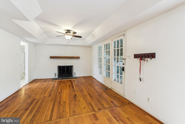 46 Misty Ln, Stafford, VA 22556 - unfurnished living room featuring wood-type flooring, a raised ceiling, ceiling fan, and a fireplace with flush hearth