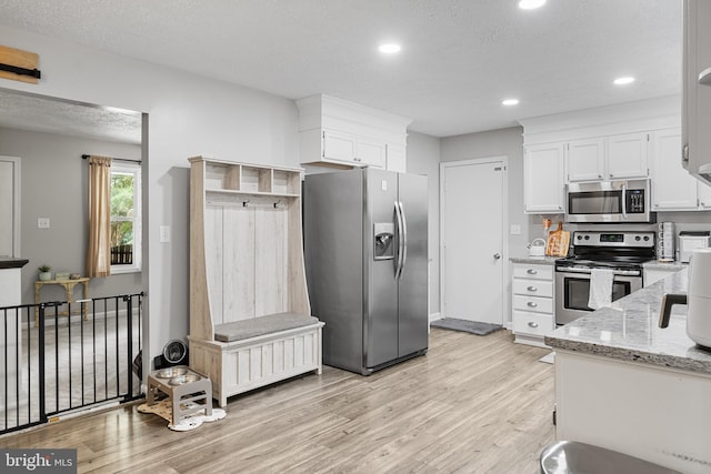 27073 Carrie Ct, Mechanicsville, MD 20659 - kitchen with appliances with stainless steel finishes, light wood-style flooring, white cabinetry, light stone countertops, and recessed lighting