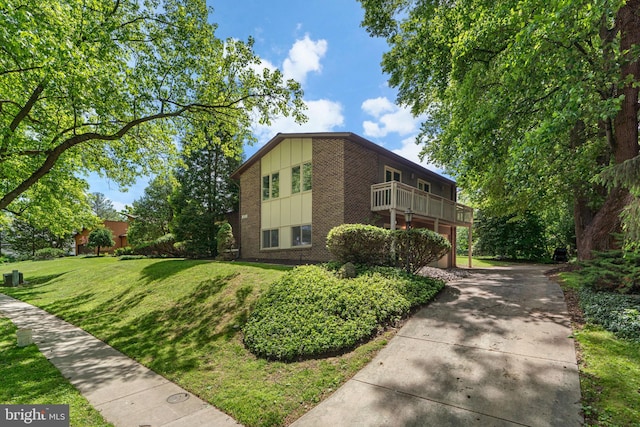 11111 Willow Bottom Dr, Columbia, MD 21044 - view of property exterior featuring brick siding, a yard, driveway, board and batten siding, and a balcony
