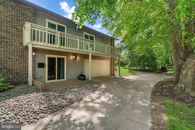 11111 Willow Bottom Dr, Columbia, MD 21044 - back of property featuring concrete driveway, an attached garage, brick siding, and a balcony